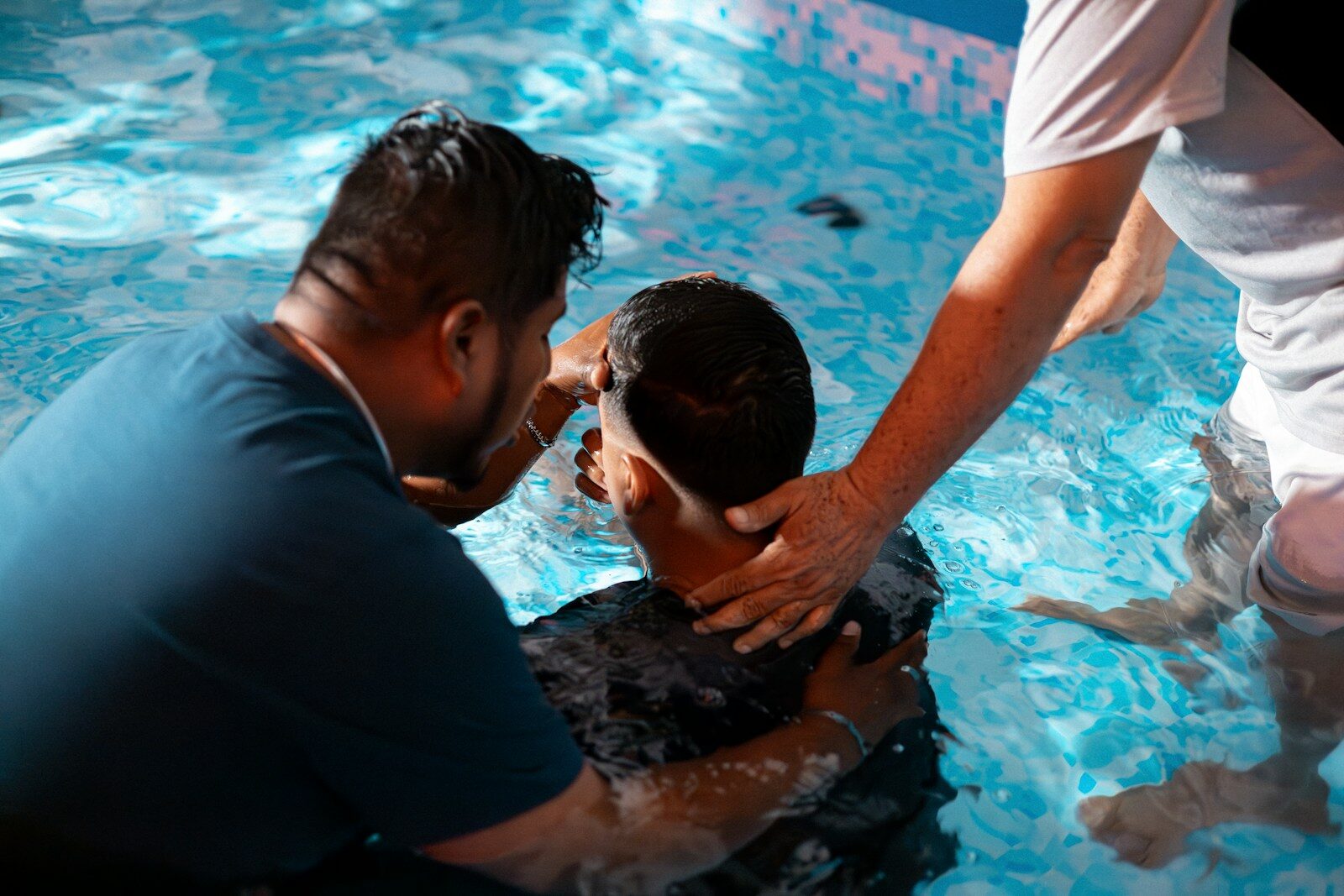 a group of people standing around a swimming pool